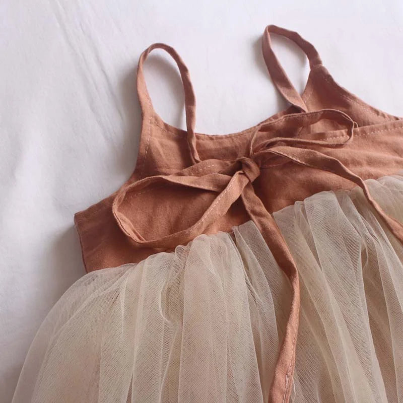 Brown dress with a sheer beige skirt on a white background