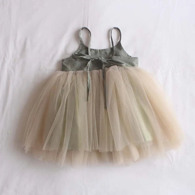 children's dress with tulle skirt hanging against a white background